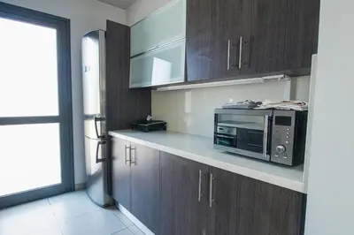 a kitchen with wooden cabinets and a microwave on a counter at Maestro Villa in Meneou