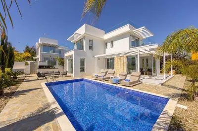 a villa with a swimming pool in front of a house at Villa Milos 36 in Protaras