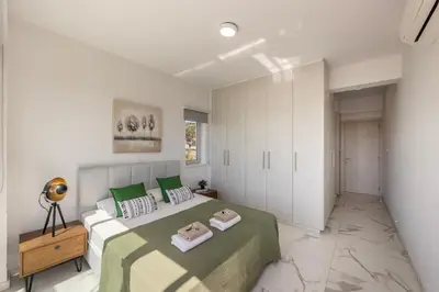 a bedroom with a bed with green and white sheets at Villa Milos 36 in Protaras