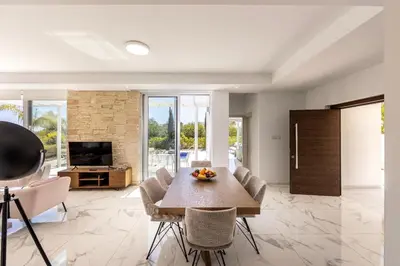 a living room with a table and chairs and a television at Villa Milos 36 in Protaras
