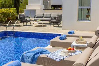 a pool with chaise lounge chairs and a swimming pool at Villa Milos 36 in Protaras