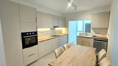 a kitchen with a wooden table and a dining room at Kanika 3 bedroom city beach in Limassol