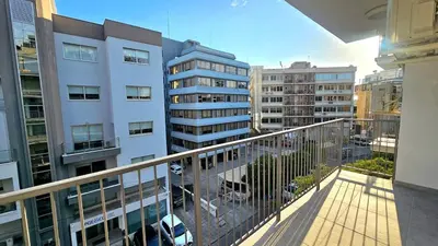 a balcony with a view of a city with tall buildings at Kanika 3 bedroom city beach in Limassol