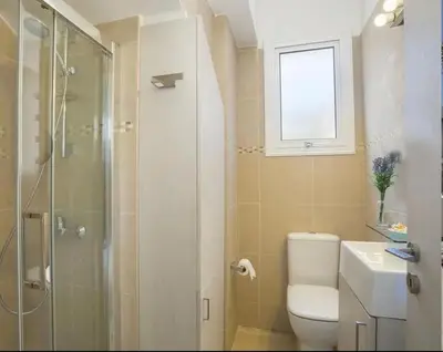 a bathroom with a shower and a toilet and a sink at Sandy Feet Beach House in Paralimni