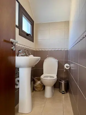 a bathroom with a white toilet and a sink at Lazuli Zen Villa with Private Pool in Pyla