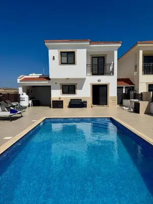 a villa with a swimming pool in front of a house at Lazuli Zen Villa with Private Pool in Pyla