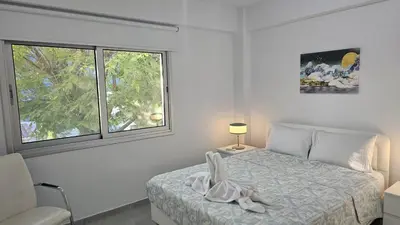a white bedroom with a bed and a window at STAY Historia Apartment in Nicosia