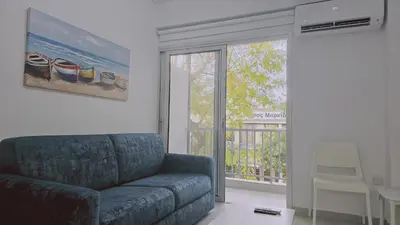 a living room with a couch and a sliding glass door at STAY Historia Apartment in Nicosia