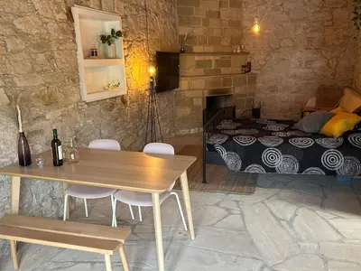 a room with a table and a bed and a table and chairs at The Hideaway in Arminou