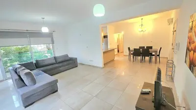 a living room with a couch and a dining room at Neapolis city apartment in Limassol