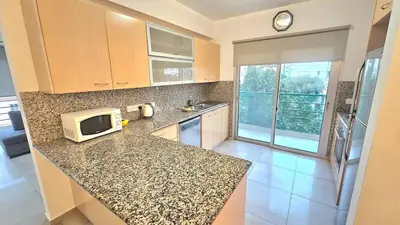 a kitchen with a granite counter top with a microwave at Neapolis city apartment in Limassol