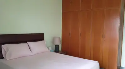 a bedroom with a white bed and wooden cabinets at Enjoy Sunrise at Spacious 3BR flat by the Seafront in Voroklini