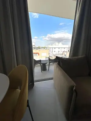 a living room with a view of a balcony with chairs at Verasia Acute Stay in Engomi in Engomi