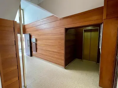a hallway with a wooden wall and a door at Centro Apartment Larnaca in Larnaka