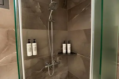 a shower with three bottles of shampoo in a bathroom at SuiteNapa22 in Ayia Napa