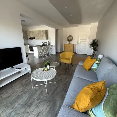 a living room with a blue couch and a table at Luxurious Penthouse in Larnaca Center 300m From The Beach in Larnaka