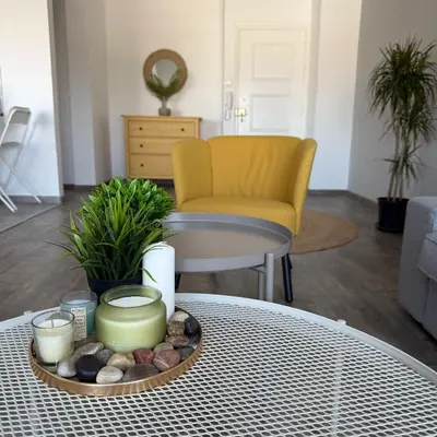 a table with a tray of candles and a yellow chair at Luxurious Penthouse in Larnaca Center 300m From The Beach in Larnaka