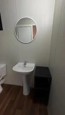 a white bathroom with a sink and a mirror at Garden Cottage Cyprus in Ayia Napa