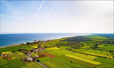 an aerial view of a green field with the ocean at Garden Cottage Cyprus in Ayia Napa