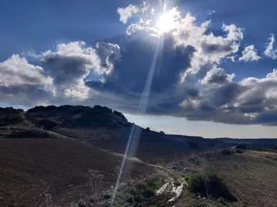 a sun shining in the sky over a dirt road at Garden Cottage Cyprus in Ayia Napa