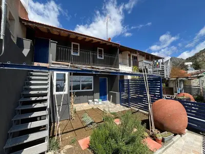 a house with blue doors and stairs in the yard at Odou Off-grid in Odhou