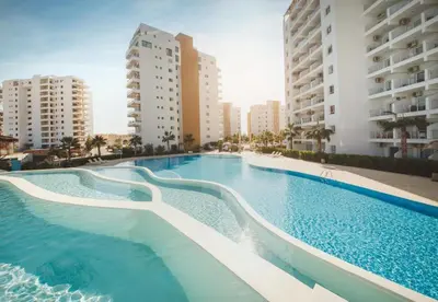 a large swimming pool with buildings in the background at CEASAR RESORT STUDIO Consus in Aglantzia