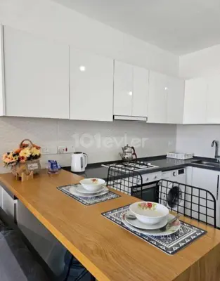 a kitchen with white cabinets and a wooden counter top at CEASAR RESORT STUDIO Consus in Aglantzia