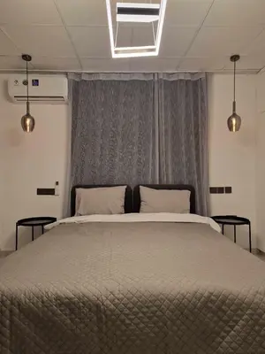 a bedroom with a large bed with two tables at Modern House in Touristic Pyla - Oroklini! in Larnaka