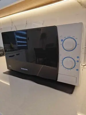 a microwave sitting on a shelf on a wall at Modern House in Touristic Pyla - Oroklini! in Larnaka