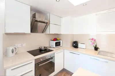 a small kitchen with white cabinets and a microwave at Apartment Marina - Beachfront in Protaras