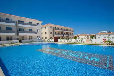 a large swimming pool in front of a building at Cozy 2-Bedroom Beach Flat in Paralimni