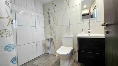a white bathroom with a toilet and a sink at Molos city centre living in Limassol