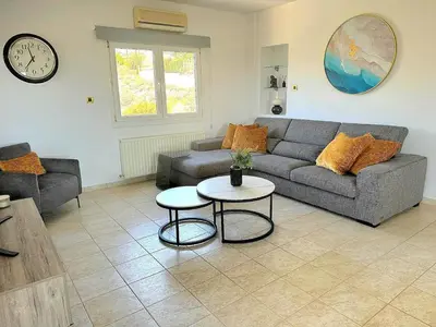 a living room with a couch and a table at Serenity Pool & Garden Villa in Limassol