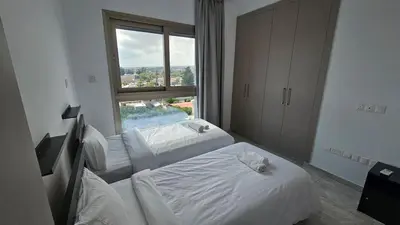 a hotel room with two beds and a window at Suburban Escape in Limassol