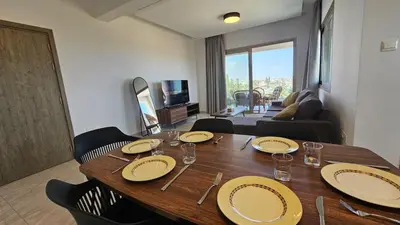 a wooden table in a living room with plates on it at Suburban Escape in Limassol