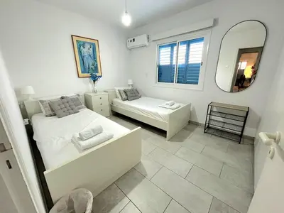 a bedroom with two beds and a mirror at Kapparis Avenue Beach Apartment in Paralimni
