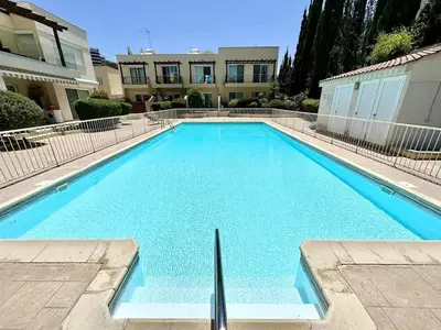 a large blue swimming pool in front of a building at Cydonia Gardens Maisonette with shared pool in Limassol