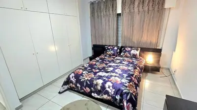 a bedroom with a bed with a floral blanket at Dasoudi beach apartment in Limassol