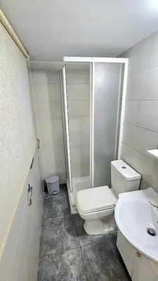 a bathroom with a toilet and a shower and a sink at Dasoudi beach apartment in Limassol