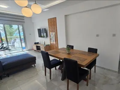 a dining room with a wooden table and chairs at Sea Breeze 3 Bed Frontline Flat in Limassol