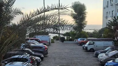 a row of cars parked in a parking lot near the ocean at Sea Breeze 3 Bed Frontline Flat in Limassol