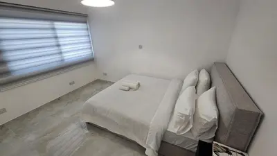 a bedroom with a bed with white sheets and pillows at Sea Breeze 3 Bed Frontline Flat in Limassol