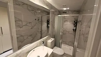 a bathroom with a sink and a shower and a toilet at The Suave - Limassol City Centre Luxury in Limassol