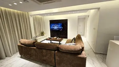 a living room with a large couch and a tv at The Suave - Limassol City Centre Luxury in Limassol