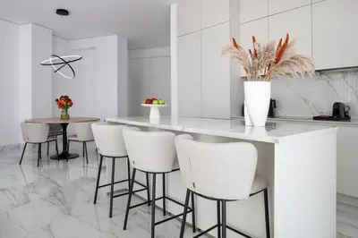 a kitchen with a white counter and stools at Trilogy Limassol Seafront in Limassol