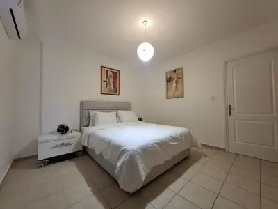 a bedroom with a white bed and a pendant light at At Patara Site, the heart of Kyrenia in Aglantzia