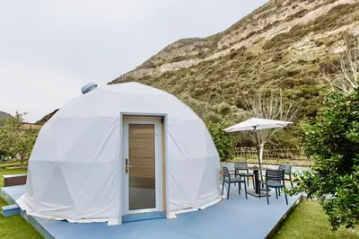a white dome tent with a table and chairs at Geometry Park in Ayios Theodhoros