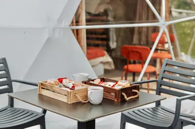 a table with two baskets of food and two cups at Geometry Park in Ayios Theodhoros