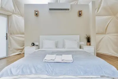 a white bedroom with a blue bed with towels on it at Geometry Park in Ayios Theodhoros