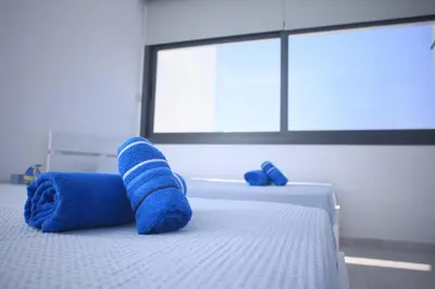 a bed with blue towels on it with a window at Elegant penthouse in City Centre in Larnaka